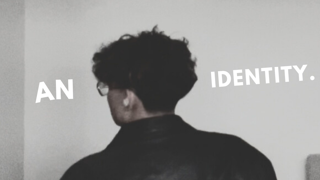 Person wearing a leather jacket with text 'AN IDENTITY.' and 'YOU.' on a gray background